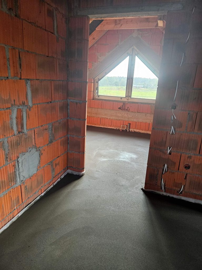 Pomieszczenie podczas budowy z przygotowaną powierzchnią podłogi
